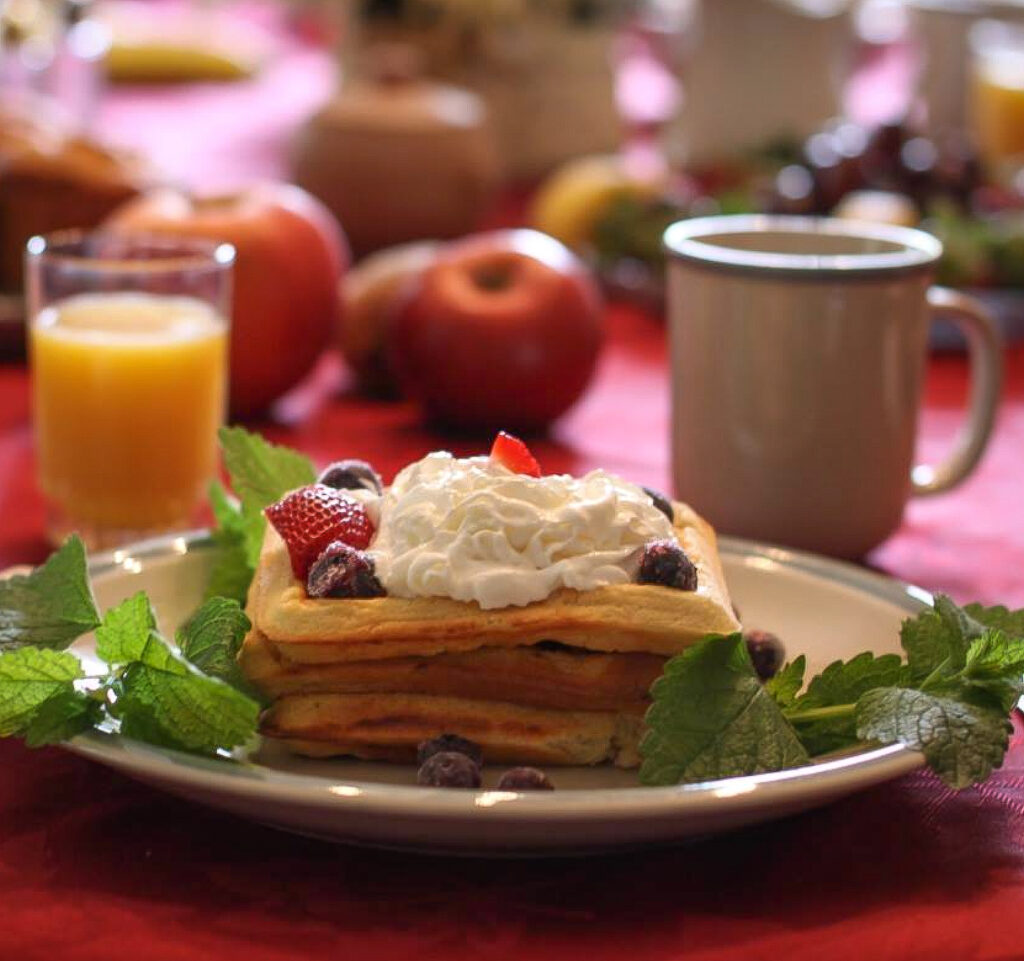 Photo of a breakfast table setting with a waffle and orange juice