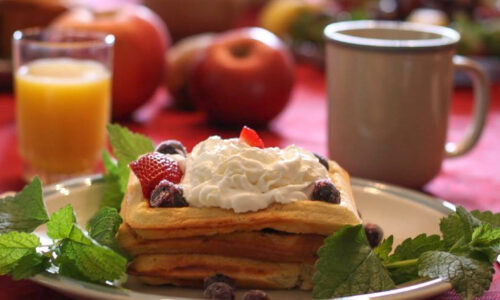 Photo of a breakfast table setting with a waffle and orange juice