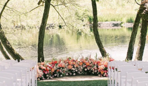 Picture of a wedding setup with chairs and flowers overlooking a large stream